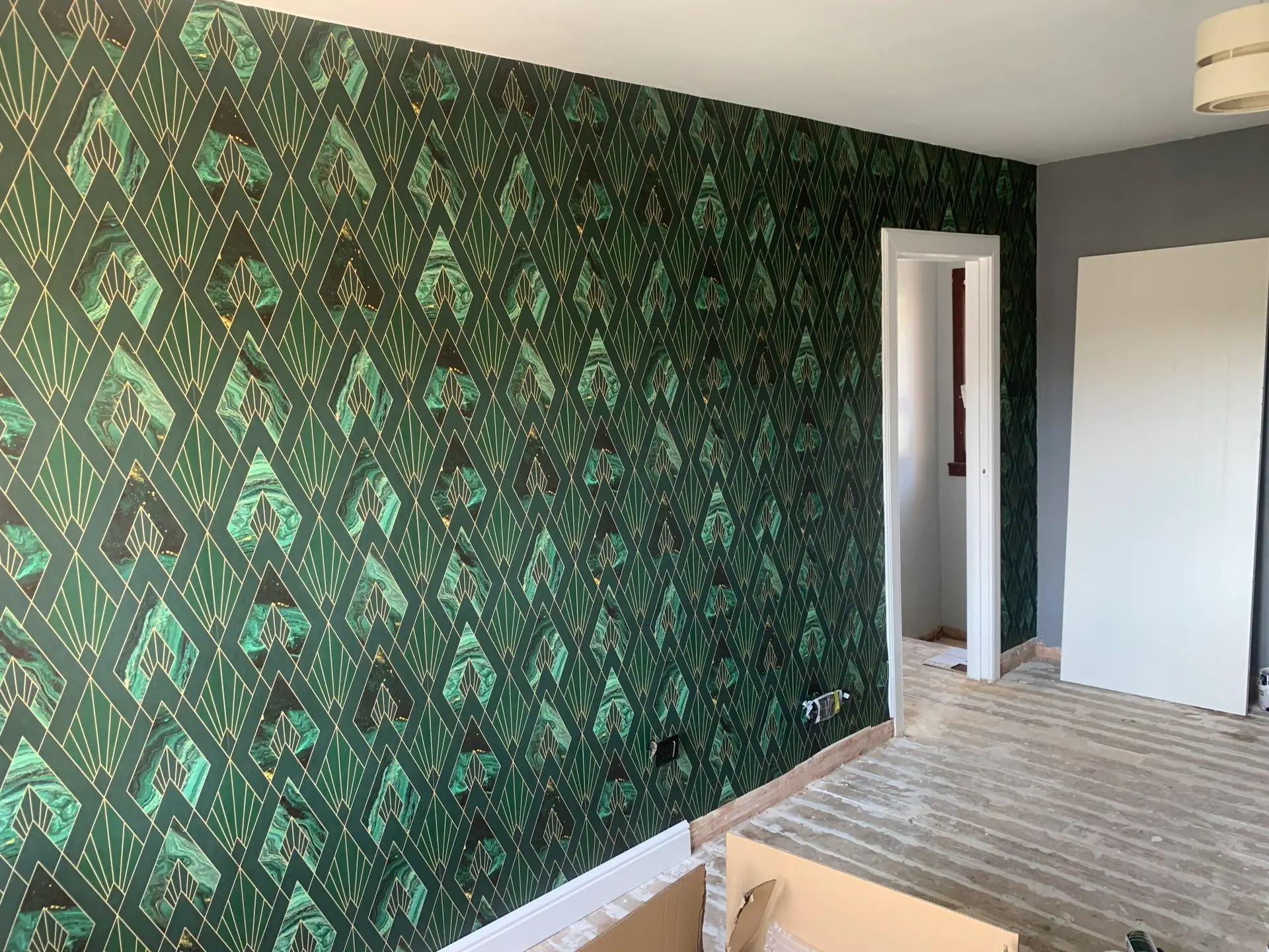 Green and gold patterned wallpaper on an interior feature wall