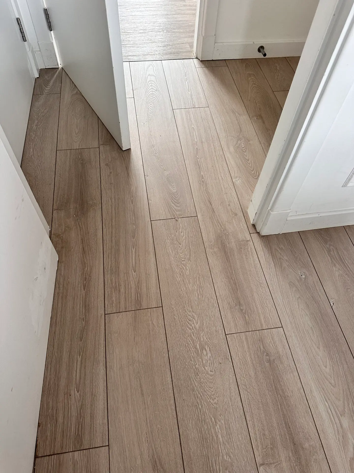 Wood-effect flooring fitted through a hallway and adjoining doorway